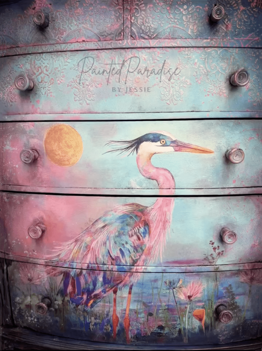 Load video: Painted Paradise by Jessie demonstrates how to apply decoupage paper to a dresser.